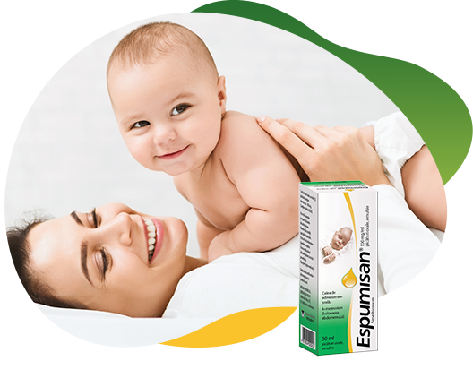 Two packs of Espumisan 100 mg Emulsion in different sizes in the foreground, behind the big package is an illustrated lion. In the background there is a happy baby that lies on his smiling mother and looking curiously at the camera
