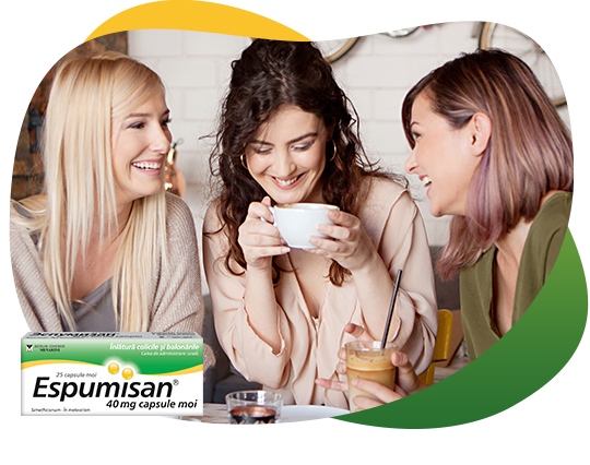 Three girlfriends drinking coffee and having a good time, sharing information about flatulence and Espumisan.There is a packshot of Espusiman 40 mg Capsules in the front.